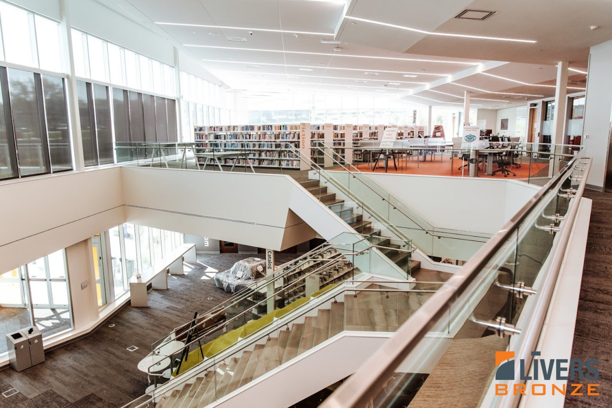 Livers Bronze Struct-U-Rail Commercial Glass Railing system installed at the lobby stair and interior balcony at the Monticello Public Library, Shawnee, Kansas, and is Made in the USA.