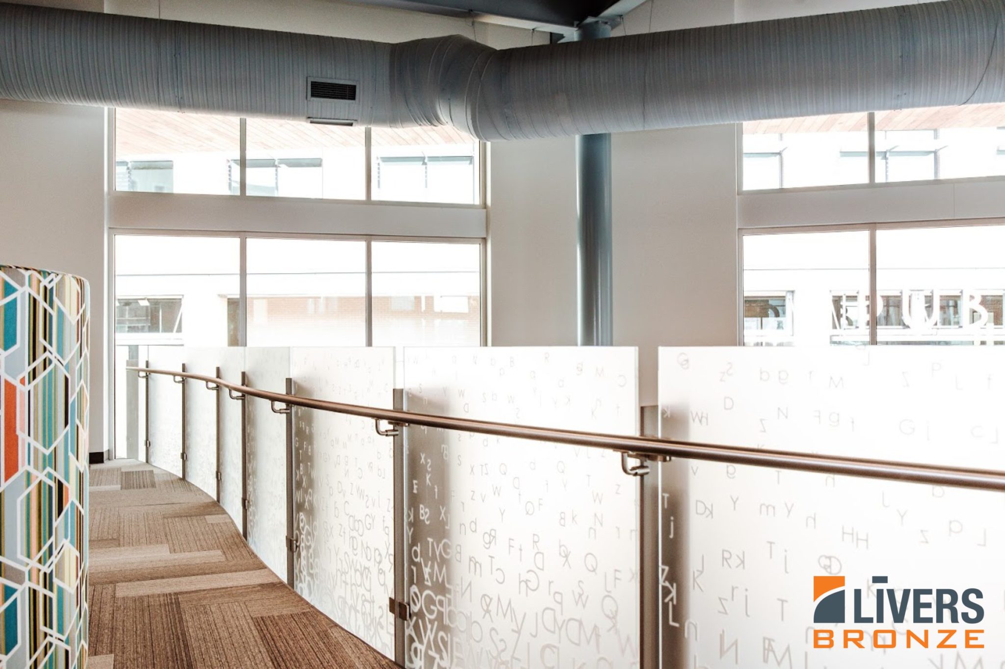 Livers Bronze Decorative Stainless Steel Railings with Steel Posts and Clear Tempered Glass Panels were installed at the interior balcony at the Lenexa City Center Library and were Made in the USA