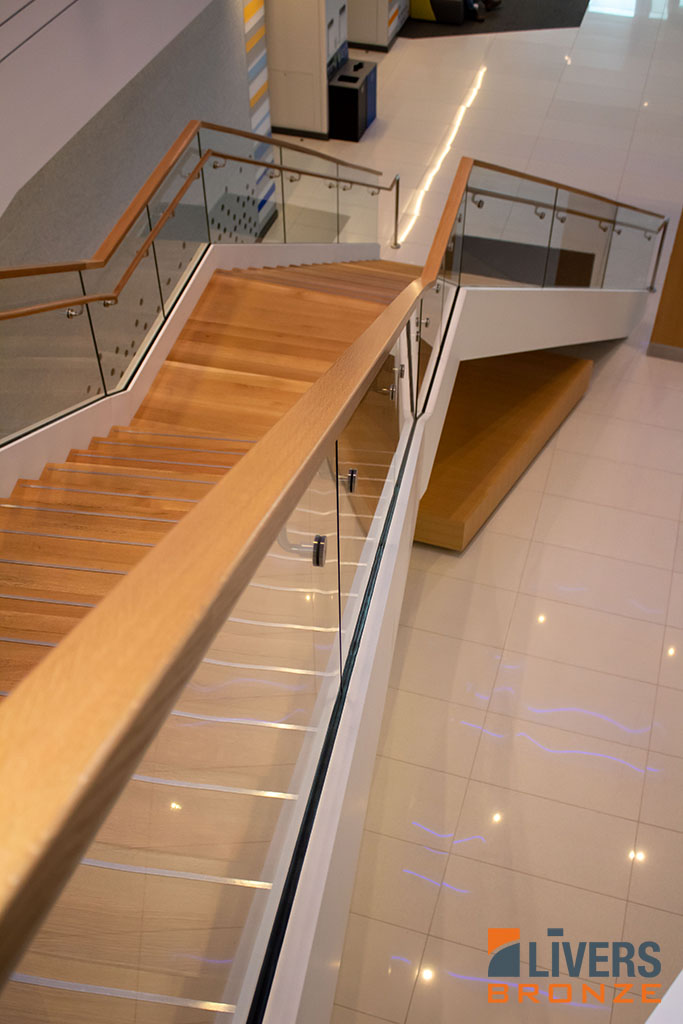 Livers Bronze Struct-U-Rail glass railings with hardwood top rails were installed at the lobby stair at Tufts University’s Joyce Cummings Center and were Made in the USA.