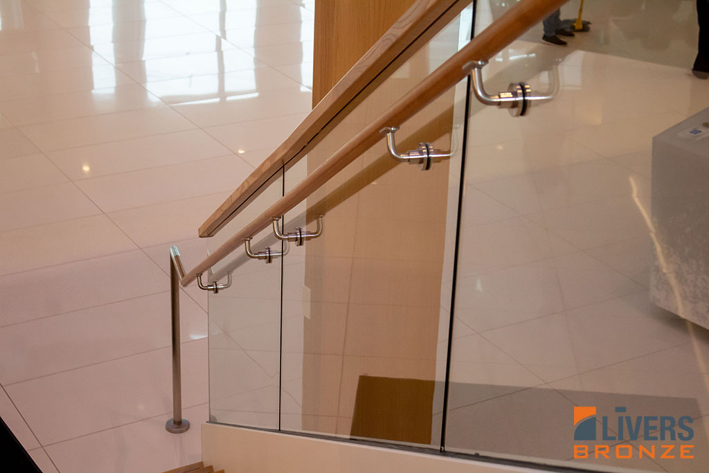 Livers Bronze Struct-U-Rail glass railings with hardwood top rails were installed at the lobby stair at Tufts University’s Joyce Cummings Center and were Made in the USA.